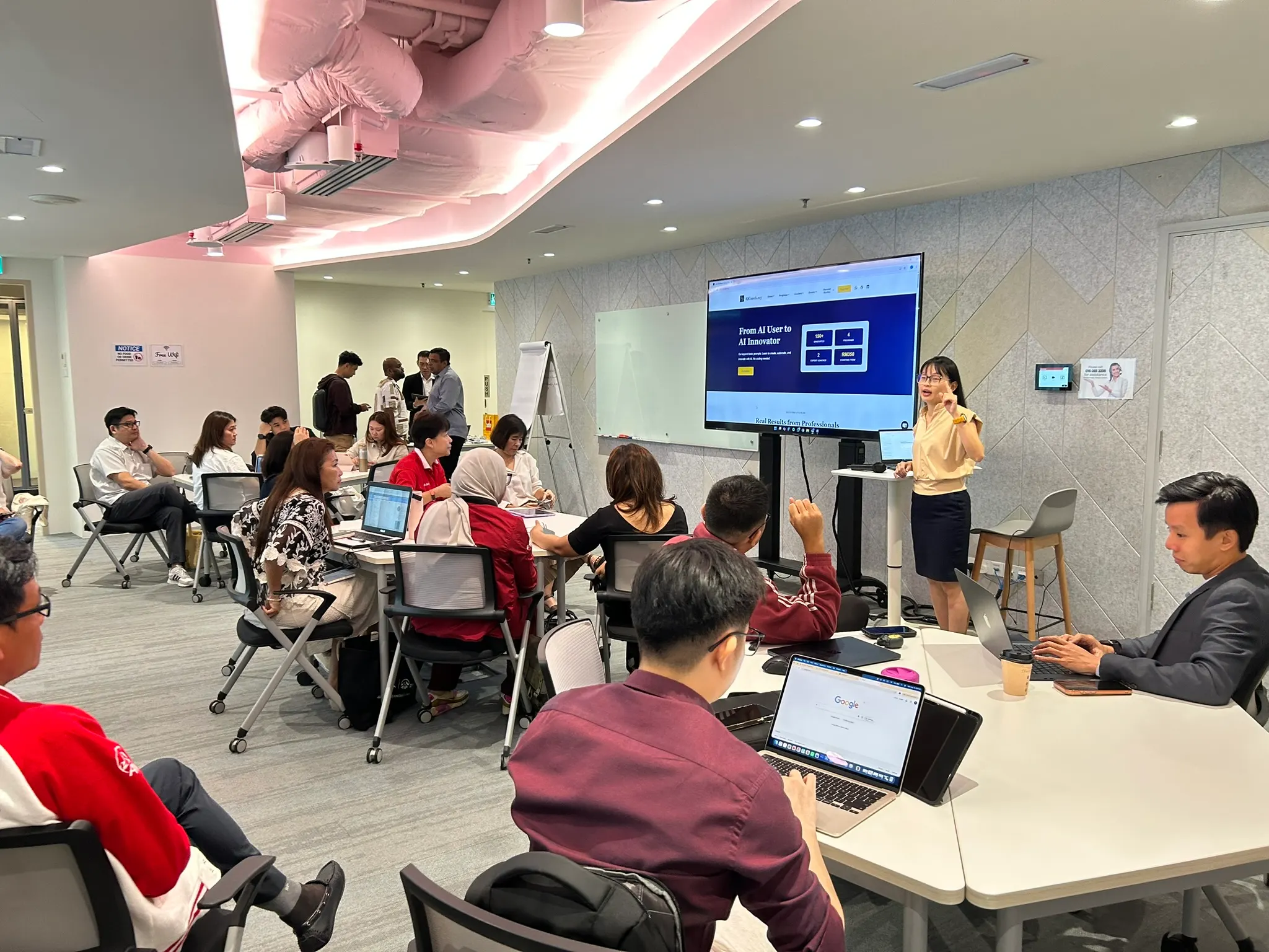 AIA advisors in Kuala Lumpur following the AICoach.my program overview on the training room screen, 18 May 2026
