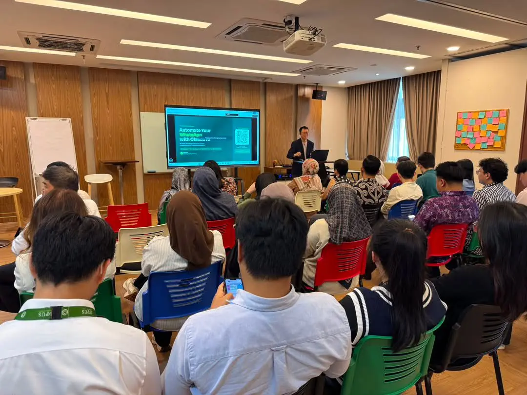 Ricky Soo presenting to a full room during the WhatsApp automation session, with the Automate Your WhatsApp with Claude AI slide on screen