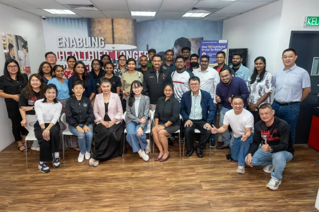 A large group of advisors and trainers posing together in front of a wall mural after a full-day AI training session in Seremban, 8 October 2026