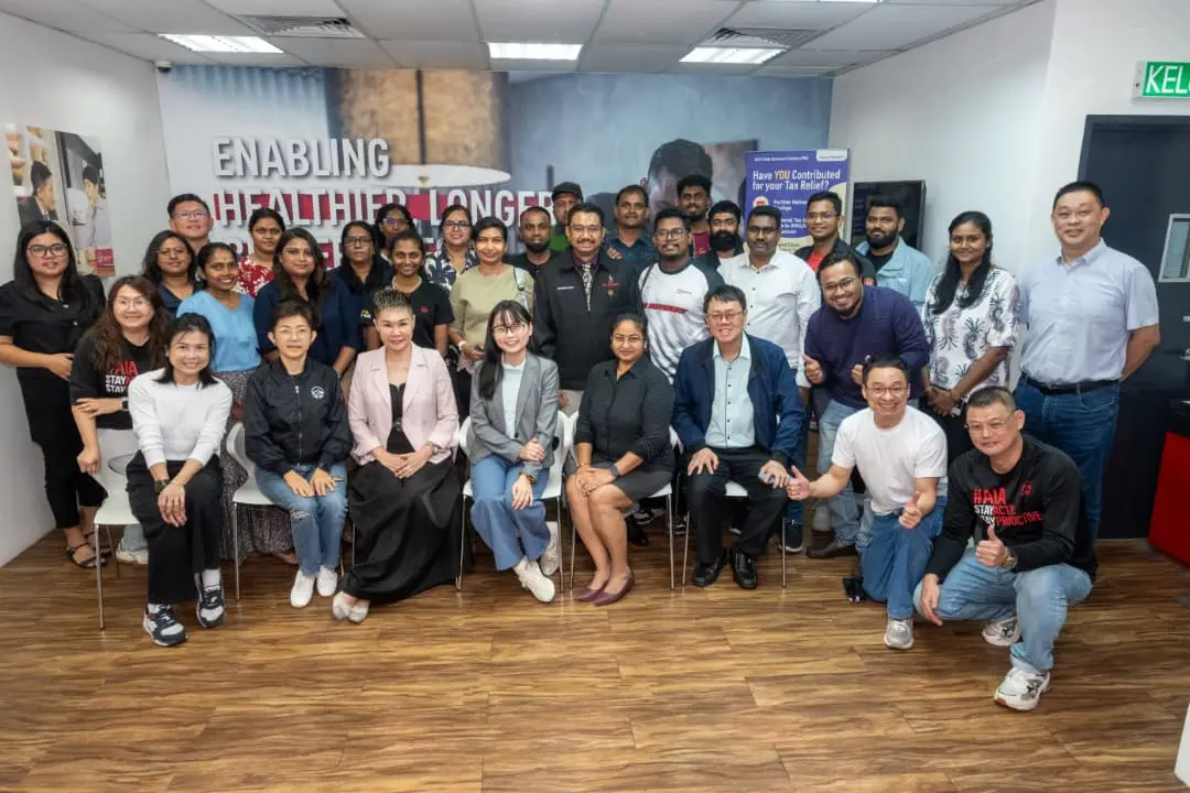 A large group of advisors and trainers posing together in front of a wall mural after a full-day AI training session in Seremban, 8 October 2026