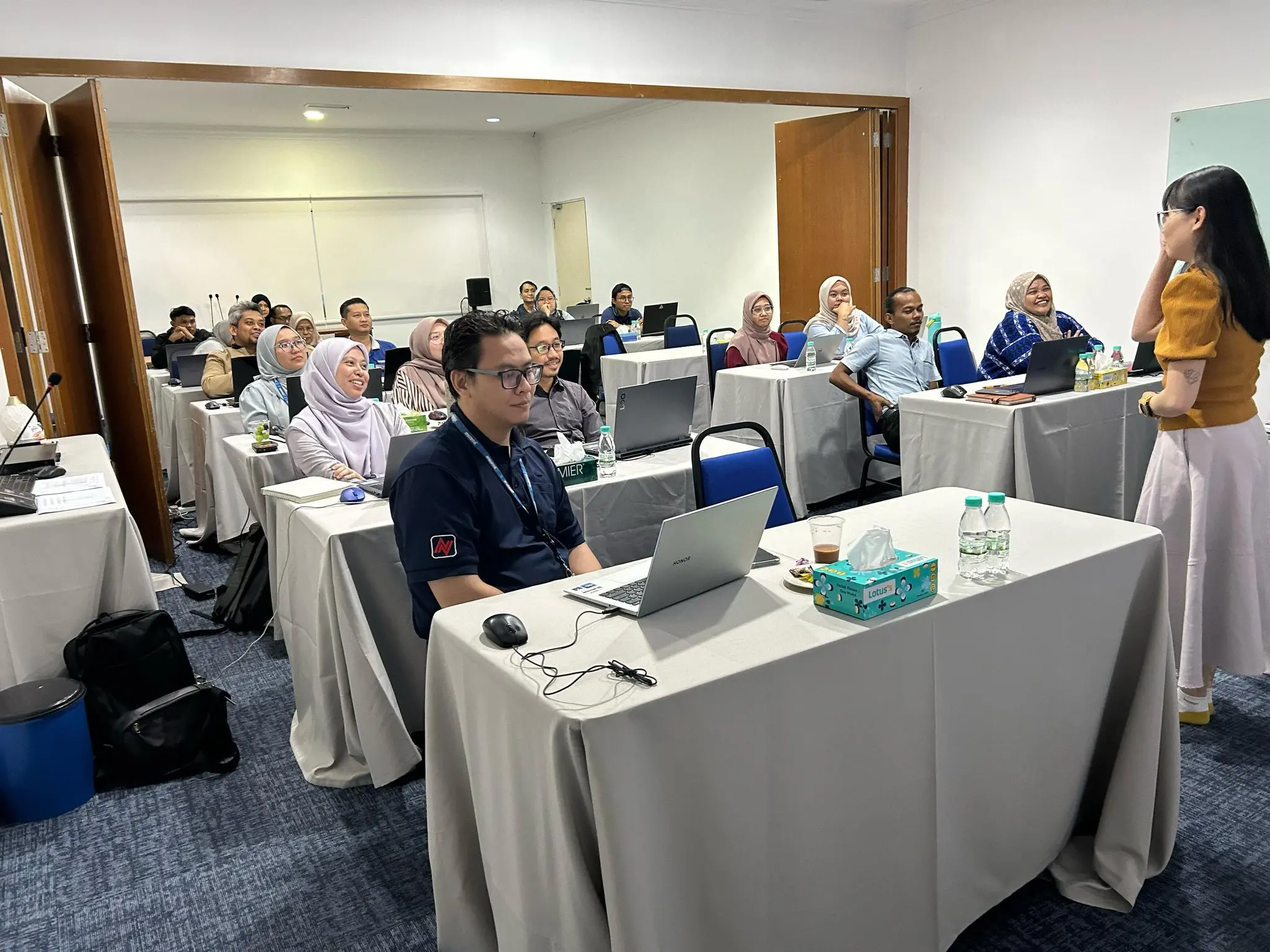 Participants at laptops during the ChatGPT Team Essentials session, with the trainer standing at the front of the room
