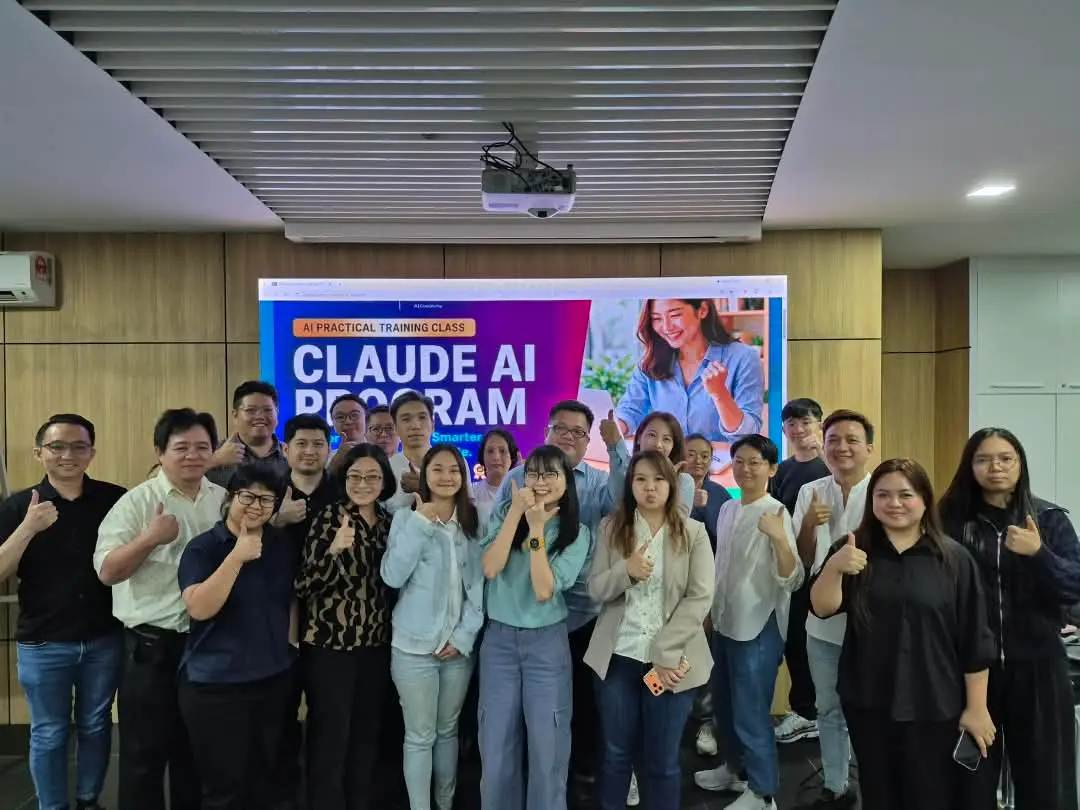 Participants and trainers giving a thumbs up in a group photo in front of the Claude AI Program title slide at GA Space, Kota Kinabalu, 30 September 2026
