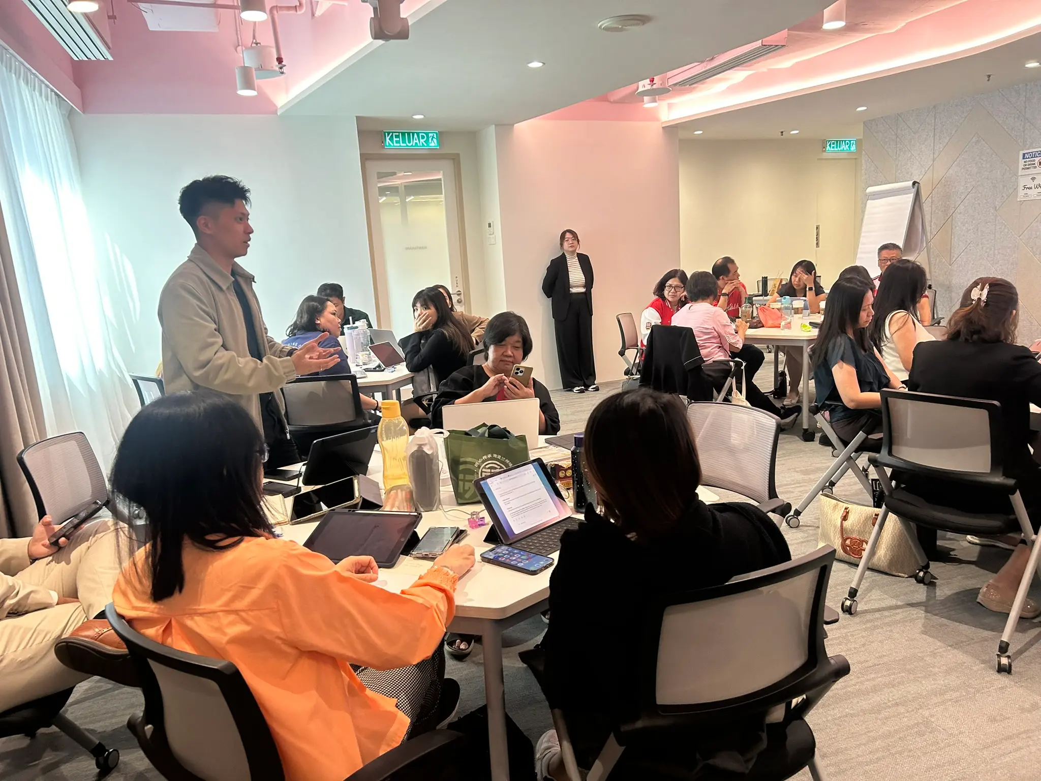 AIA advisors seated around tables mid-discussion during the third batch's session, 26 June 2026