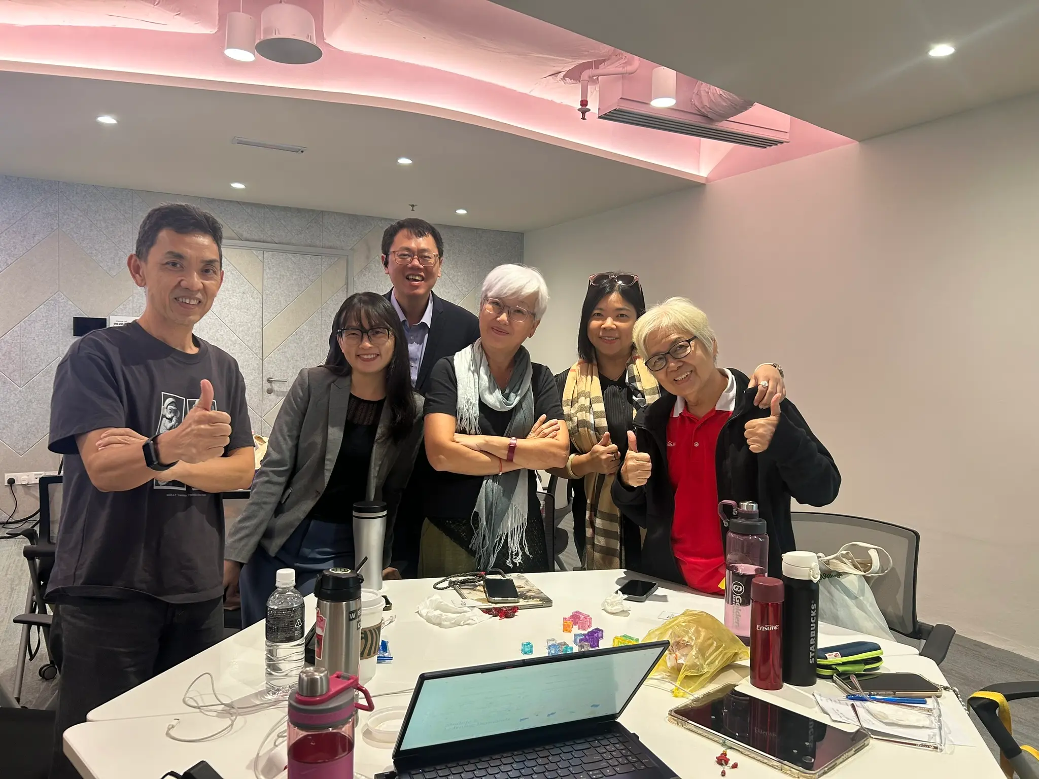 A small group of AIA advisors and the trainer giving a thumbs up at the end of the session