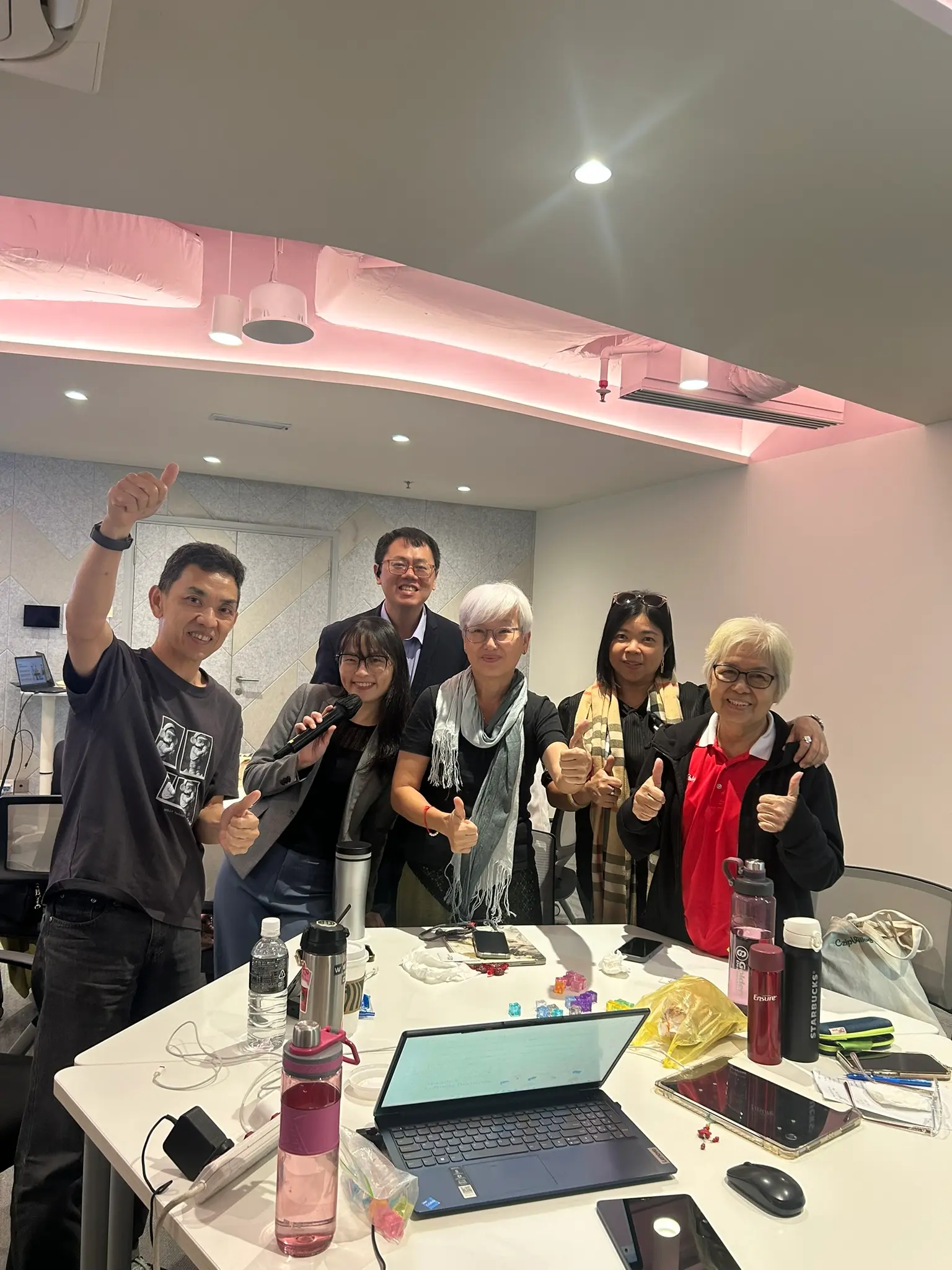 The same group of AIA advisors and the trainer, a second thumbs up around the table
