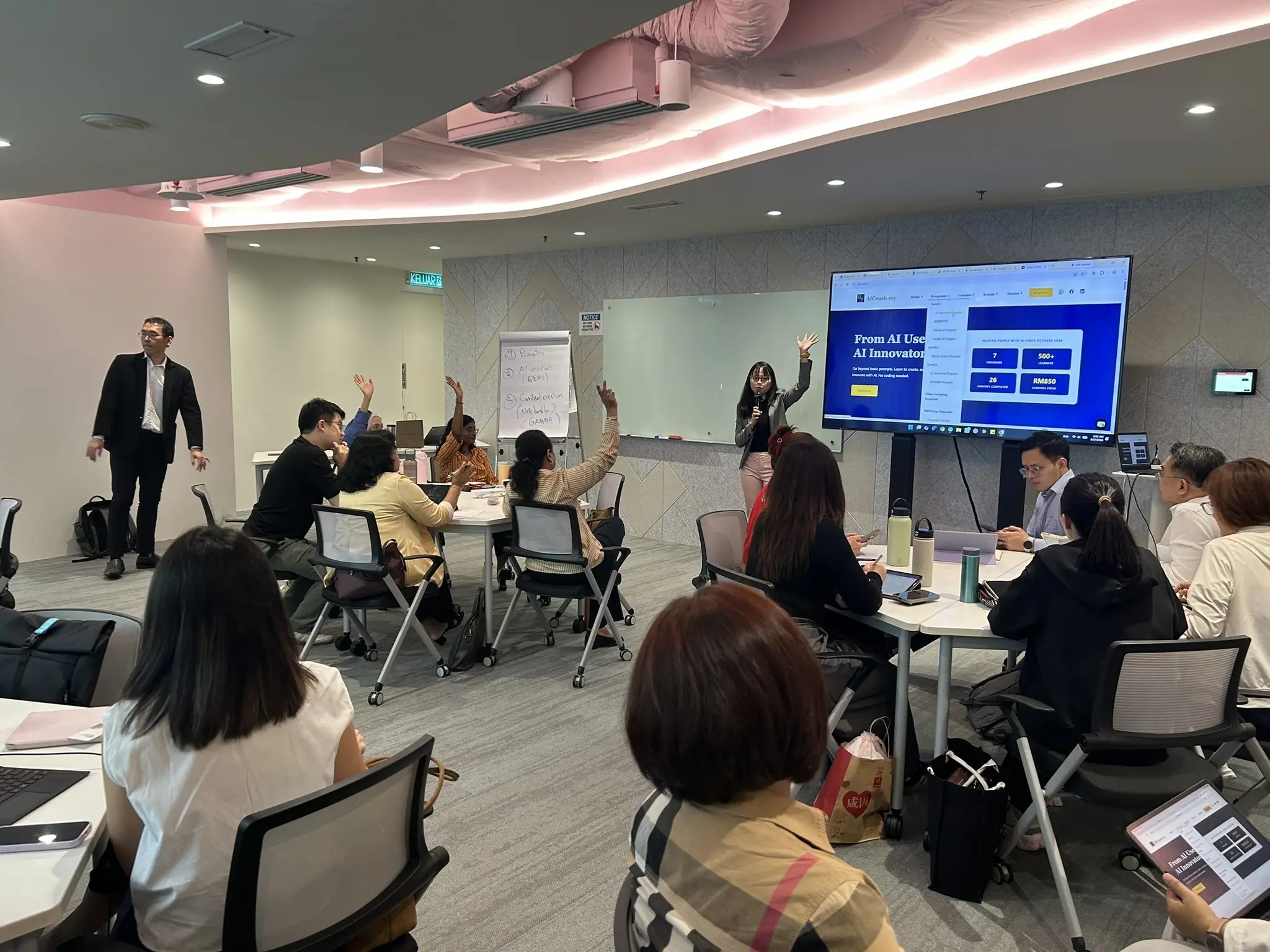 A full training room with several advisors raising their hands to answer a question