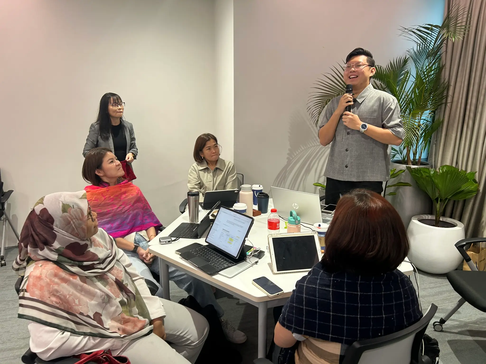 A group of advisors listening and reacting as one of them speaks into a microphone