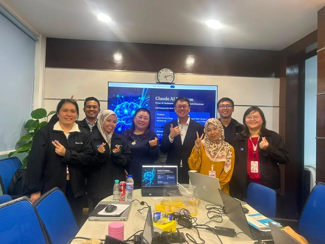Group photo of participants and trainers beside the Claude AI Program title slide at the start of a session