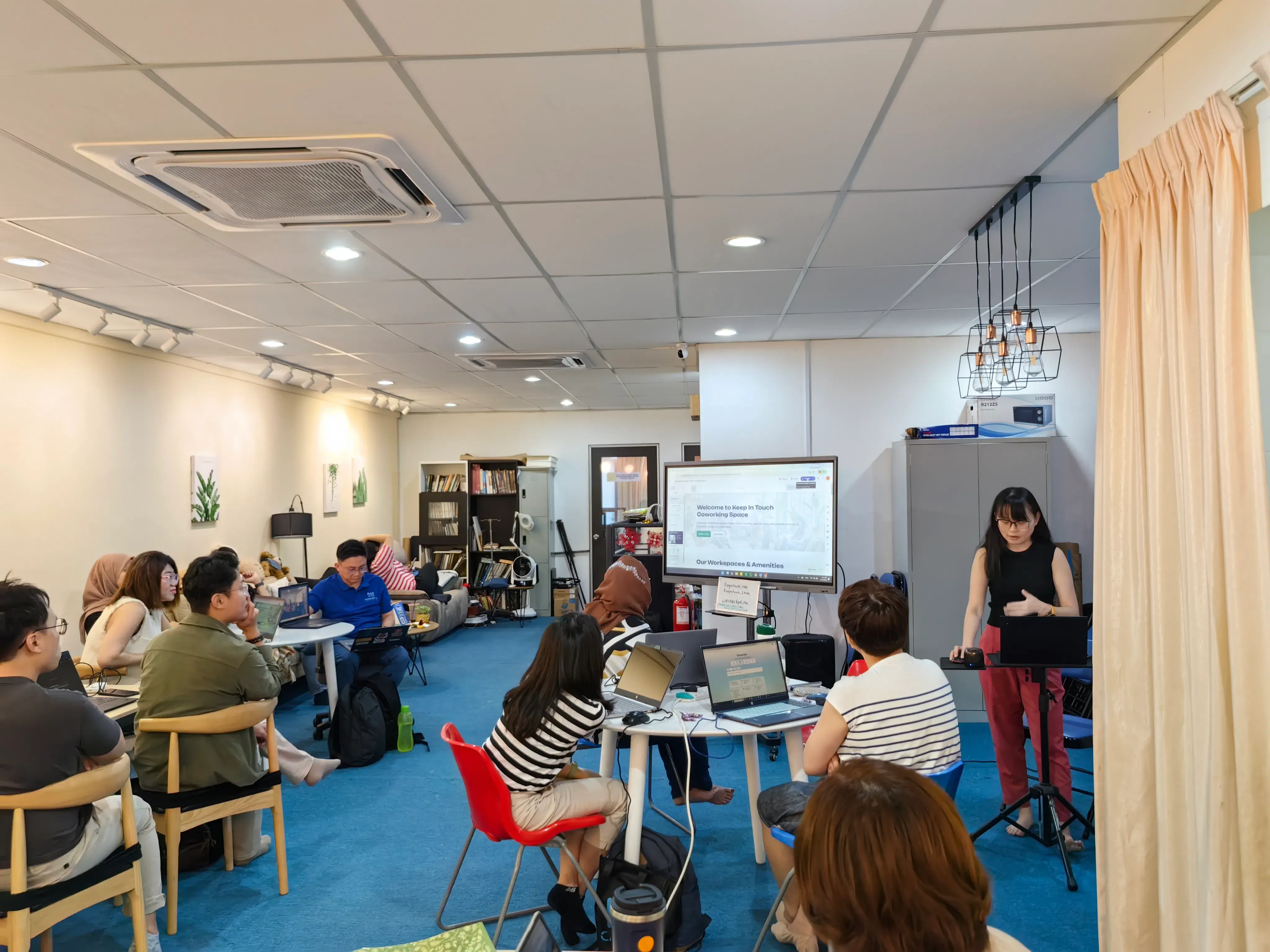 Wide view of the Inno Day #1 room, participants at laptops watching a presenter at the screen
