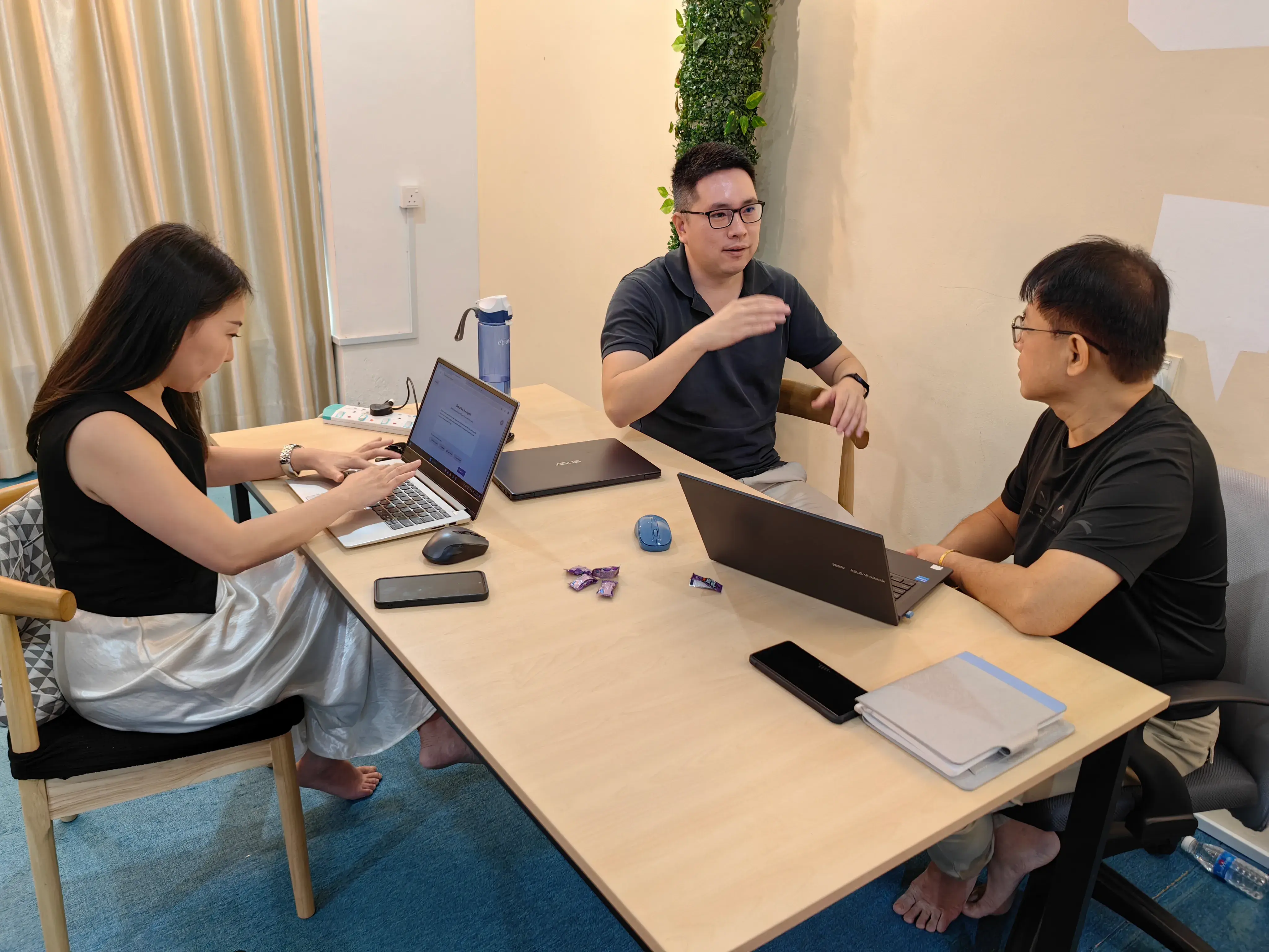 Three participants working through a build together around a table of laptops at Inno Day #1