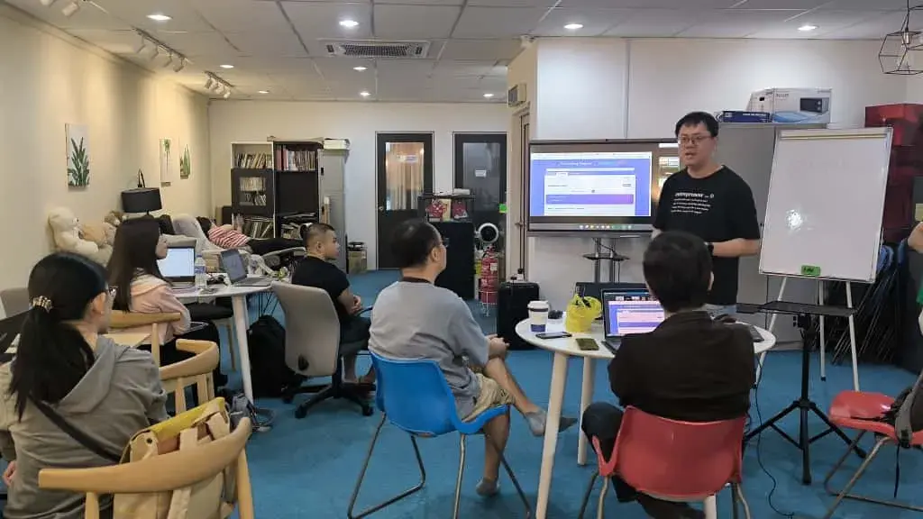 Speaker in a black t-shirt walking through a form-building demo on screen at Inno Day #2