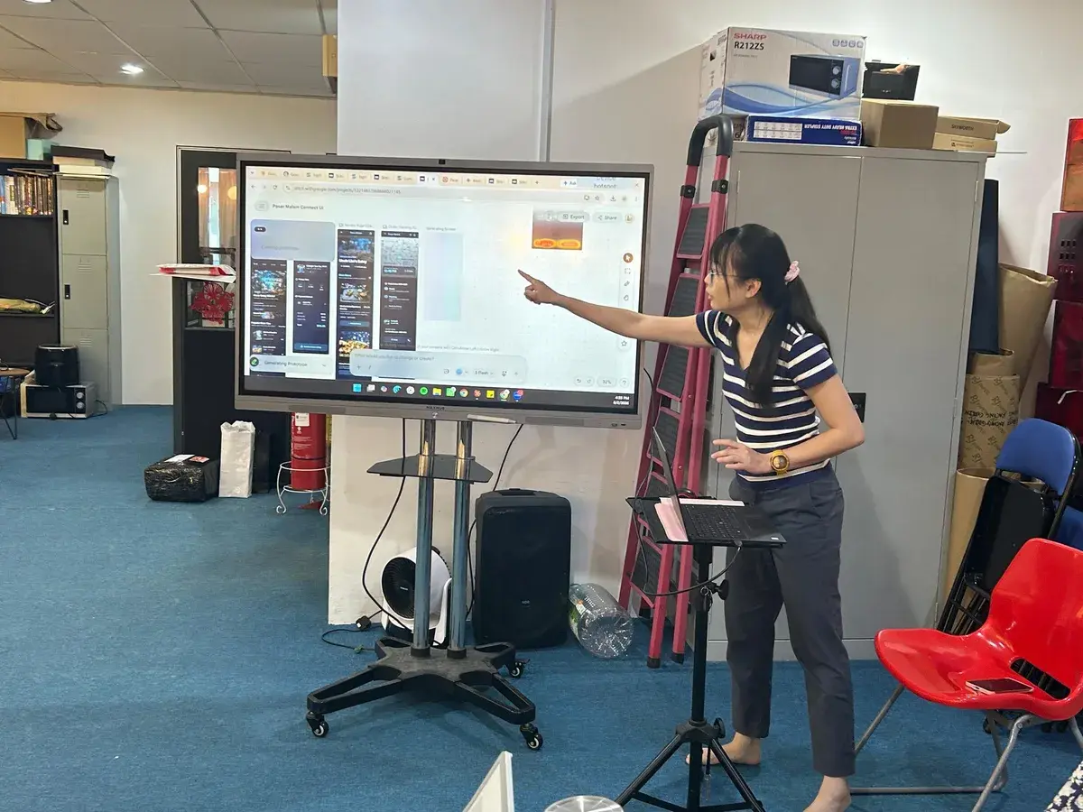 Koh Li Hong showing app interfaces generated from plain text prompts at Inno Day #6