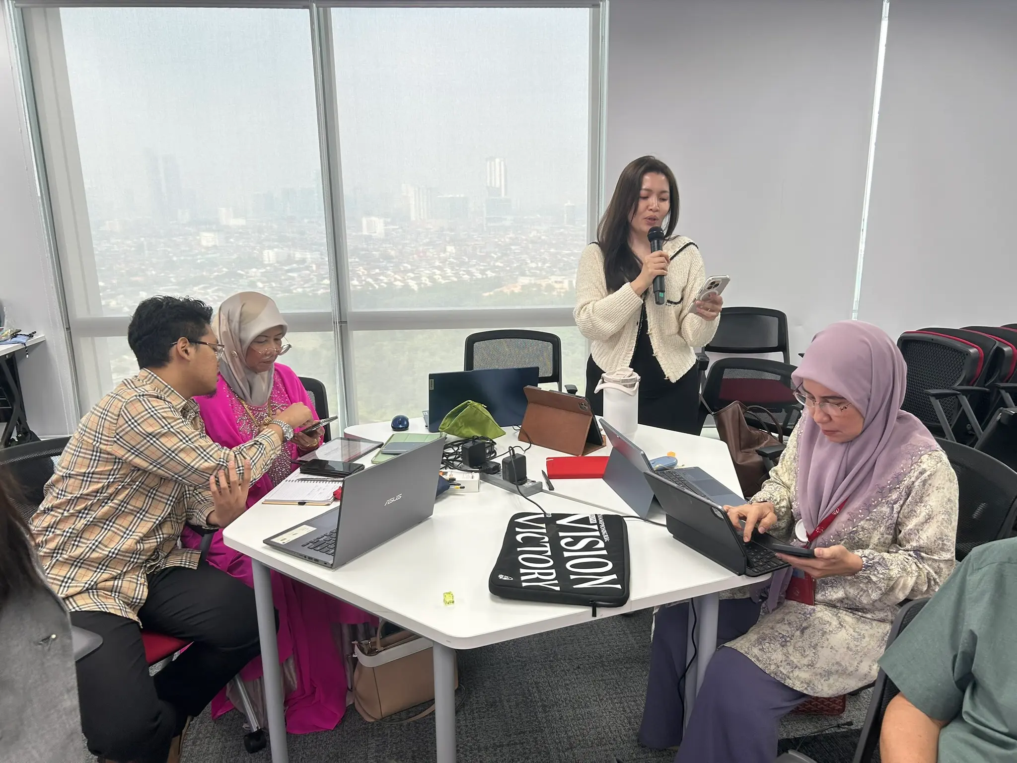 A table of advisors working beside a floor-to-ceiling window looking out over the city