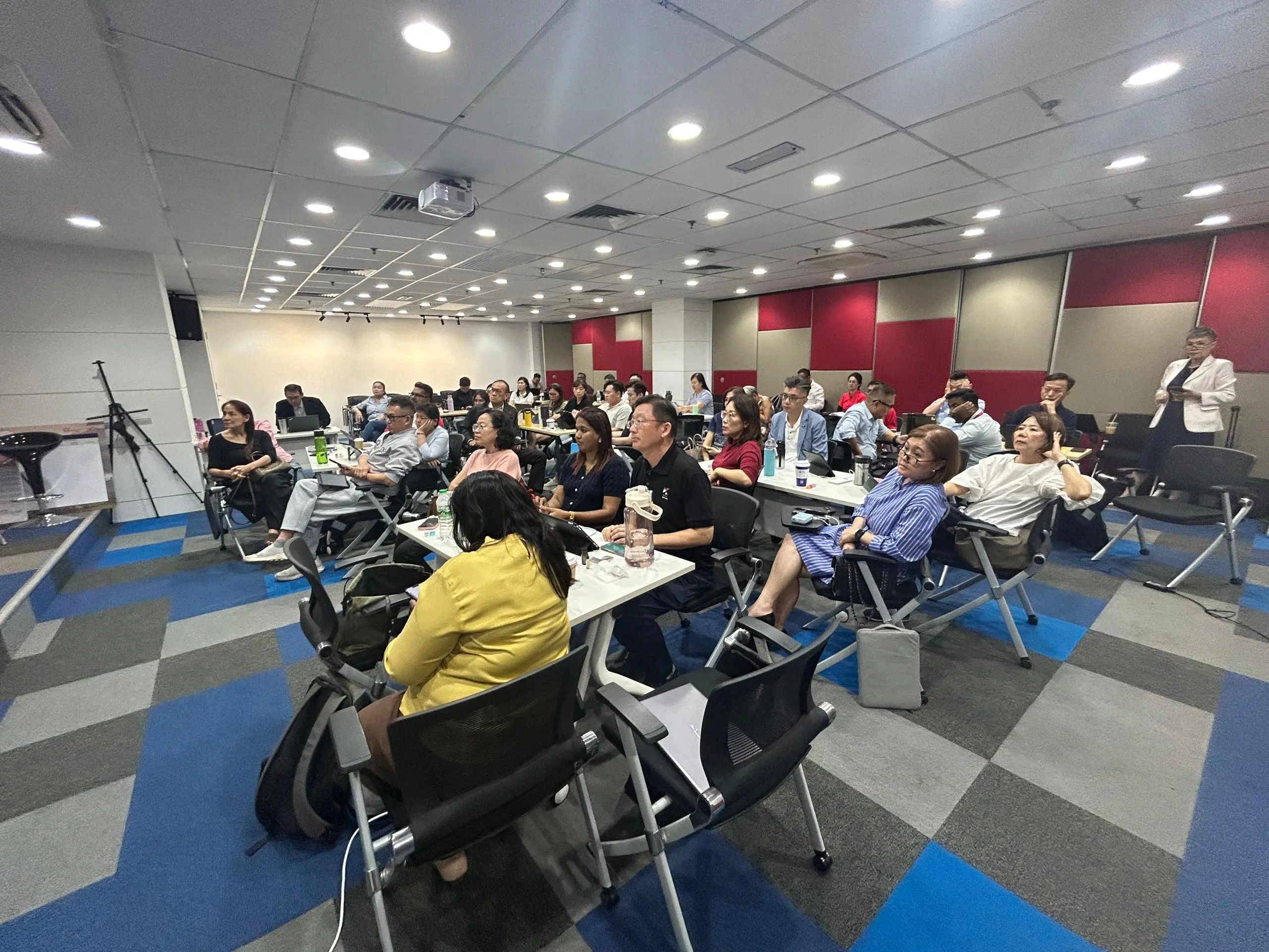 Wide view of the Klang training room, red and tan acoustic panels along the back wall