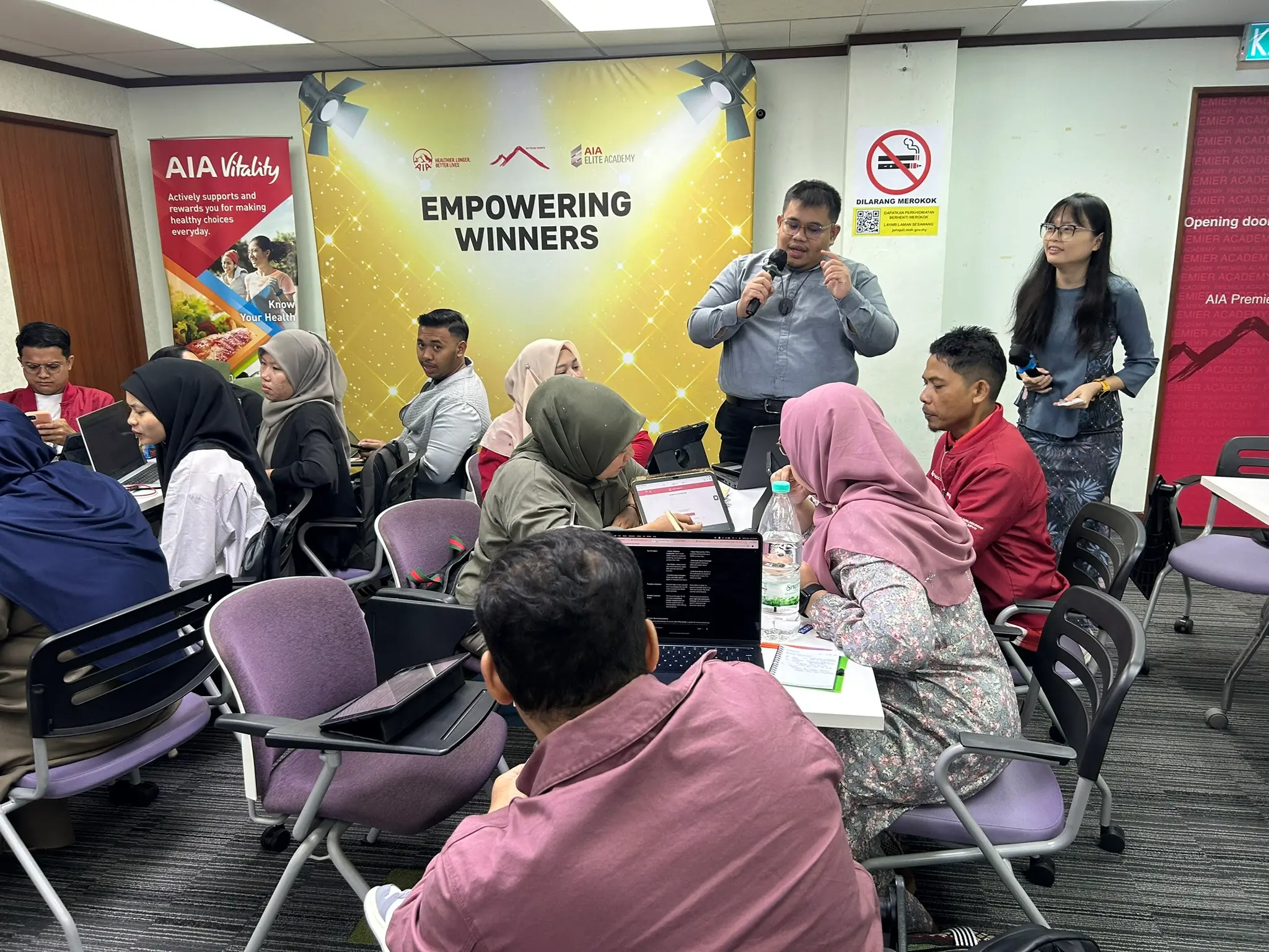Peserta bekerja di komputer riba dan tablet masing-masing sambil mendengar perkongsian
