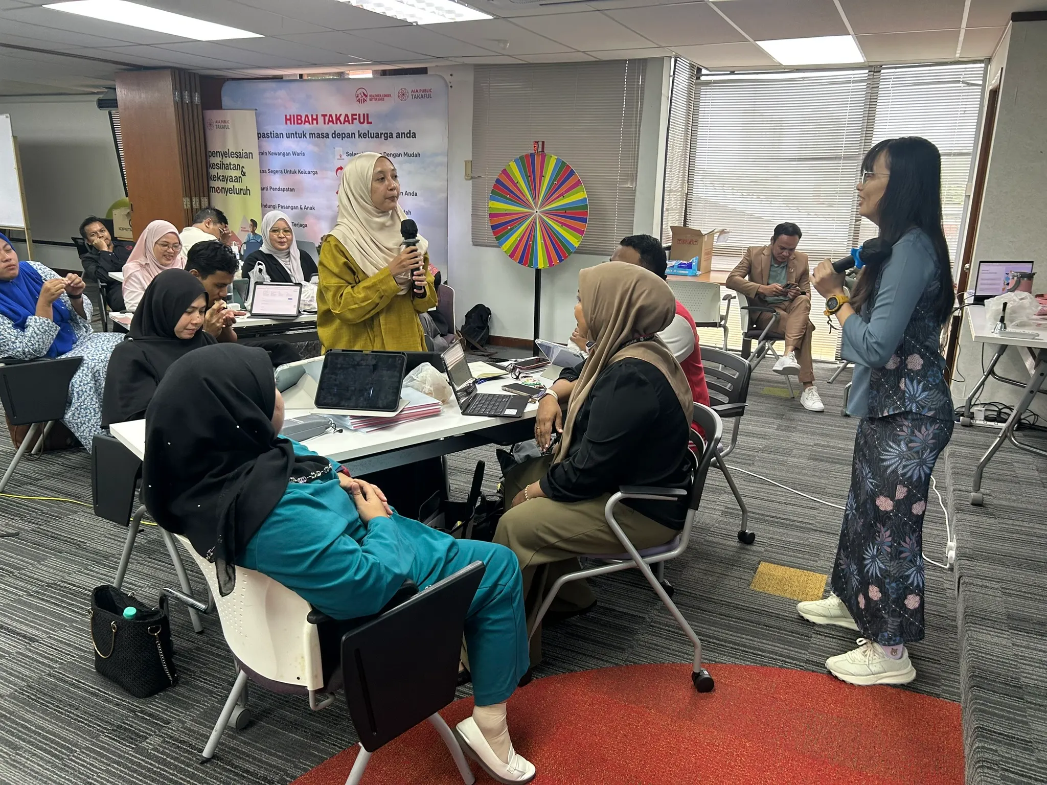 Seorang peserta berdiri memegang mikrofon untuk berkongsi di hadapan rakan-rakan dalam sesi latihan di Kota Bharu, 9 September 2026