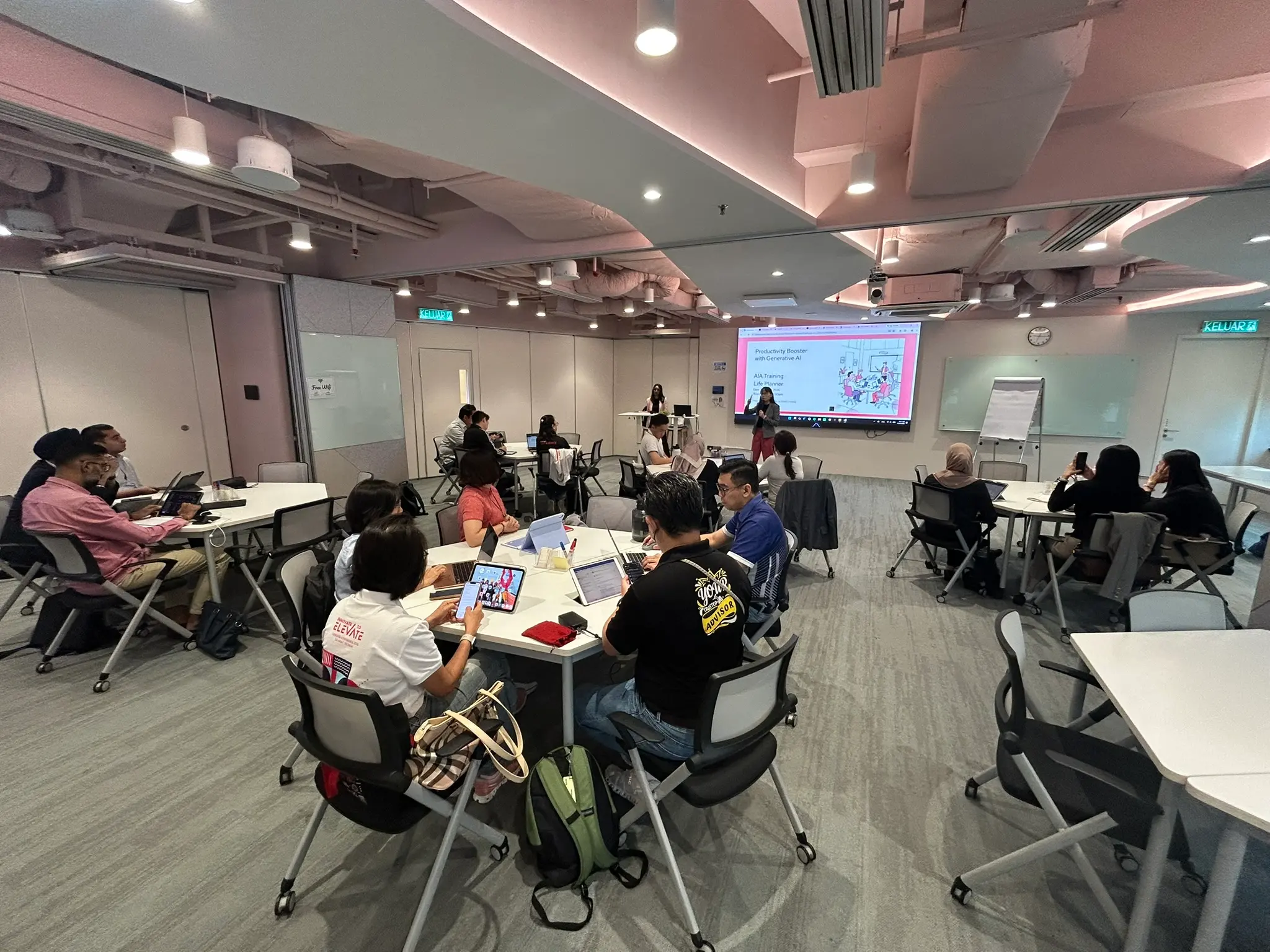 A full training room watching the opening slide on the screen at the front of the room