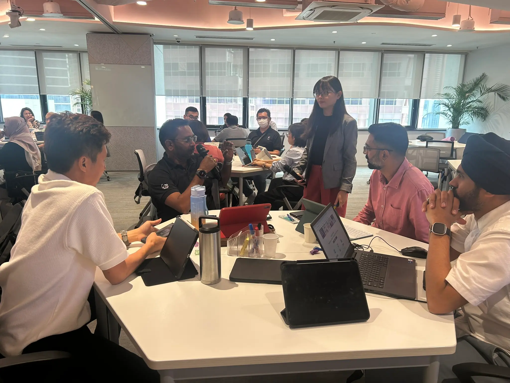 The trainer holding a microphone in conversation with another small group of advisors
