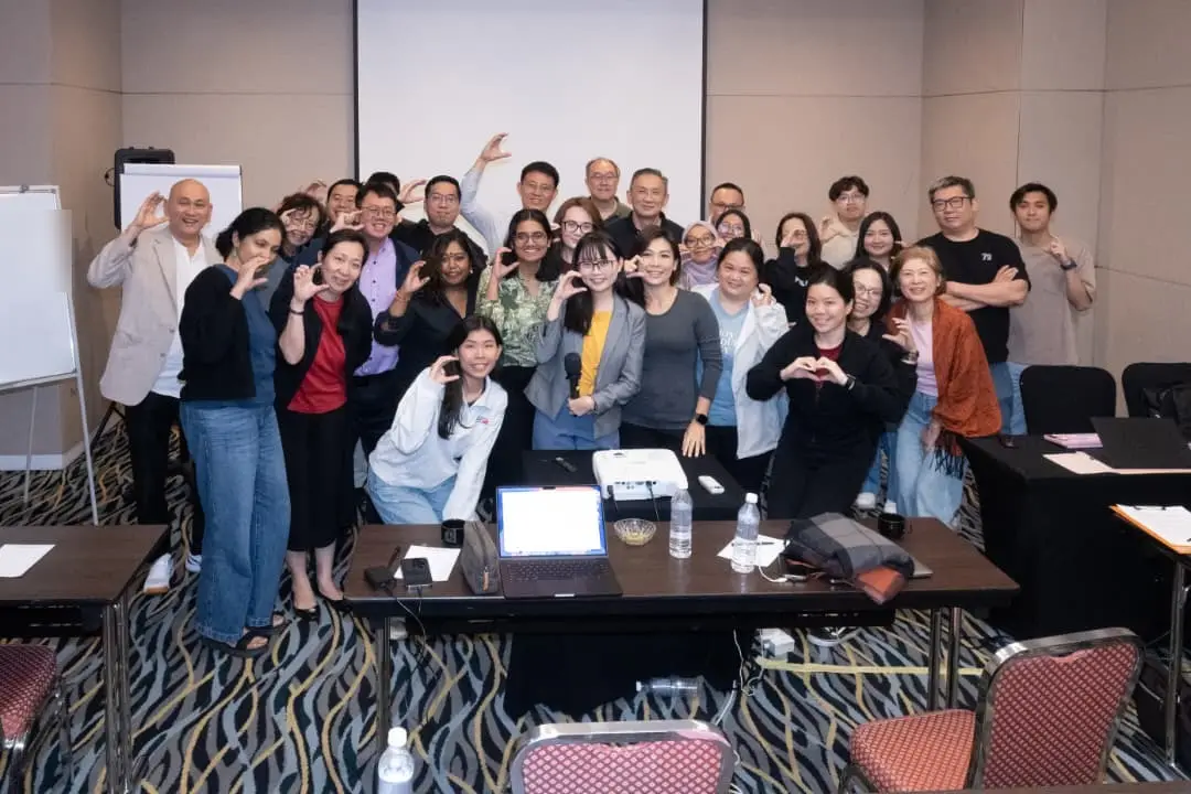 Participants and trainers from a two-day Claude AI program making heart signs with their hands in a group photo at Armada Hotel, Petaling Jaya, September 2026