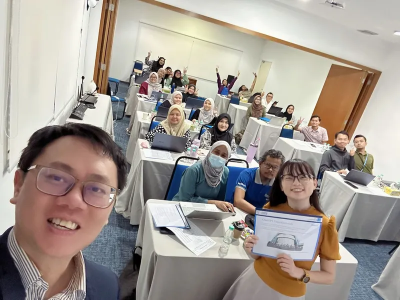 Corporate participants with laptops in conference room during AI training