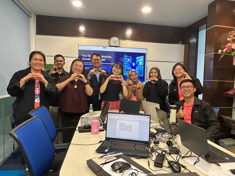 Corporate team making heart signs after completing the Claude AI training program