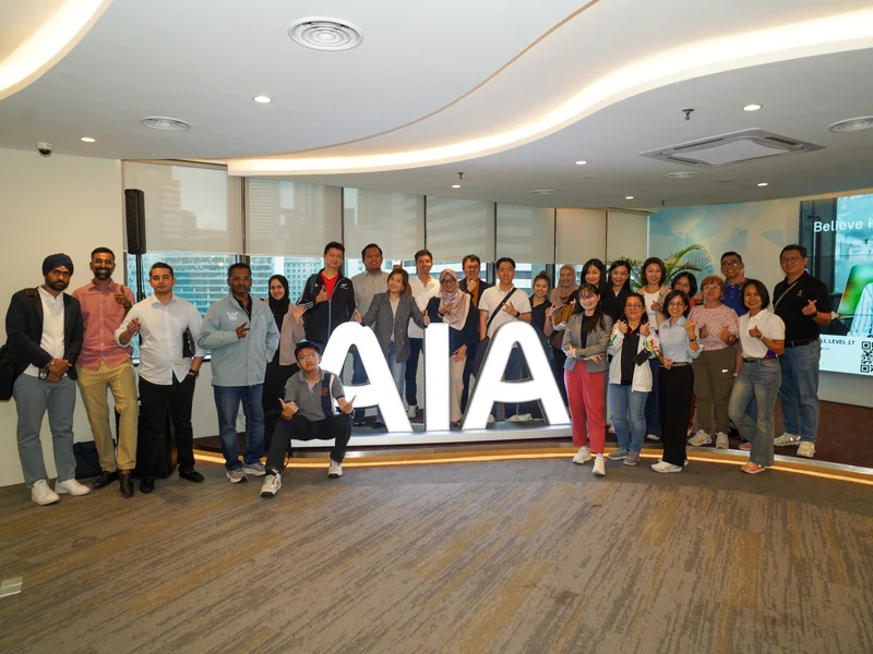 Group photo of corporate team and trainers beside the office signage after an AI training session