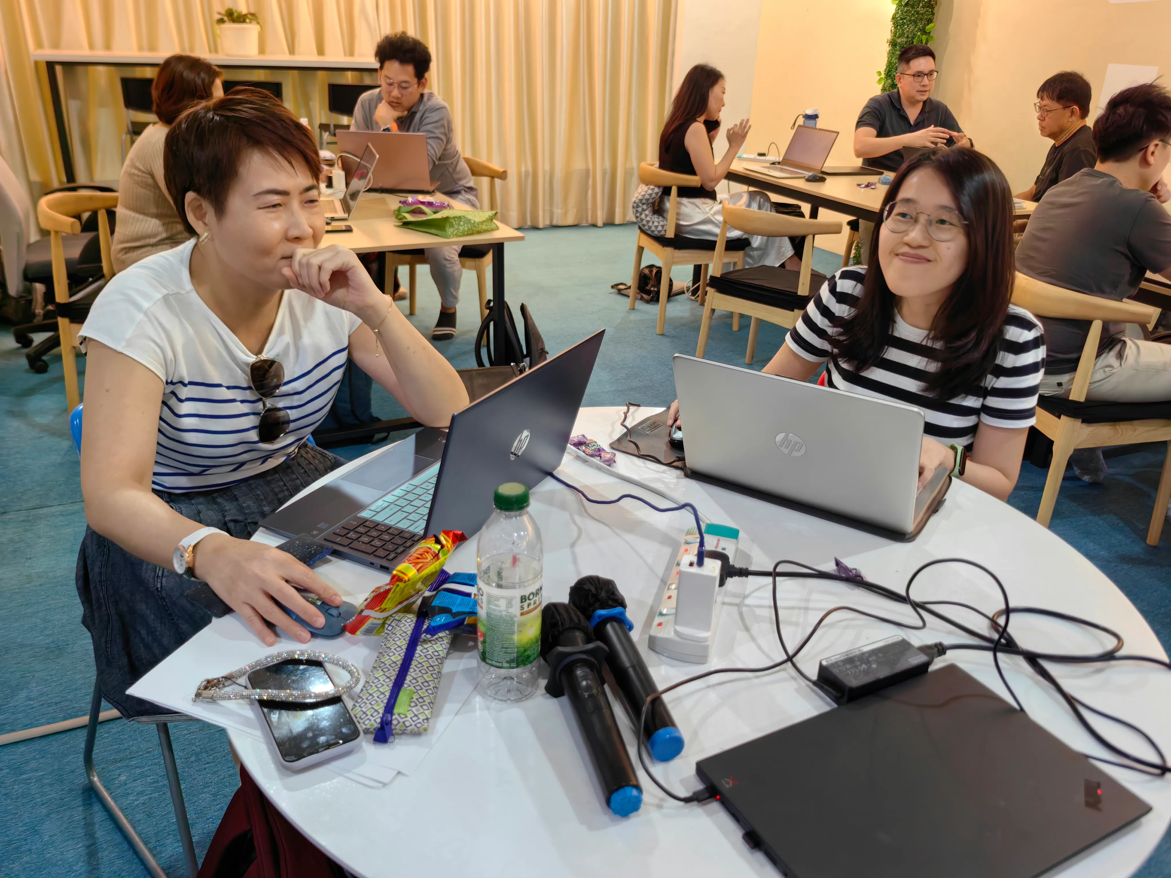 Workshop participants actively building AI solutions with laptops and tools